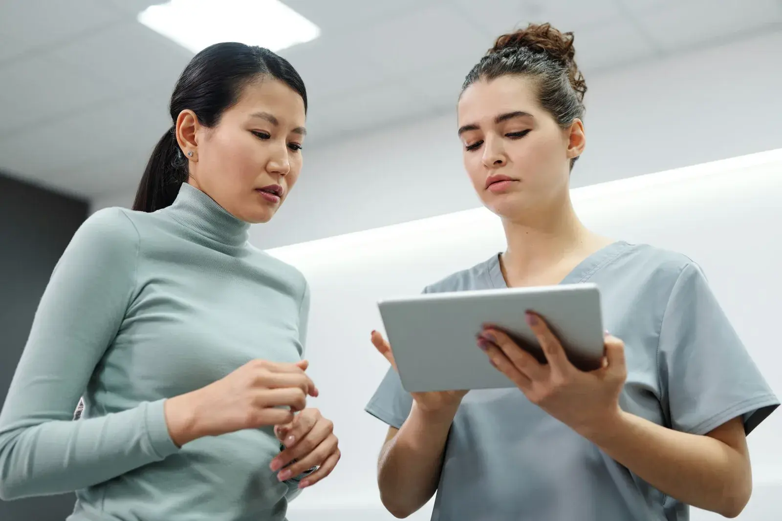 Clinician and patient discussing information on a tablet; illustrative photograph