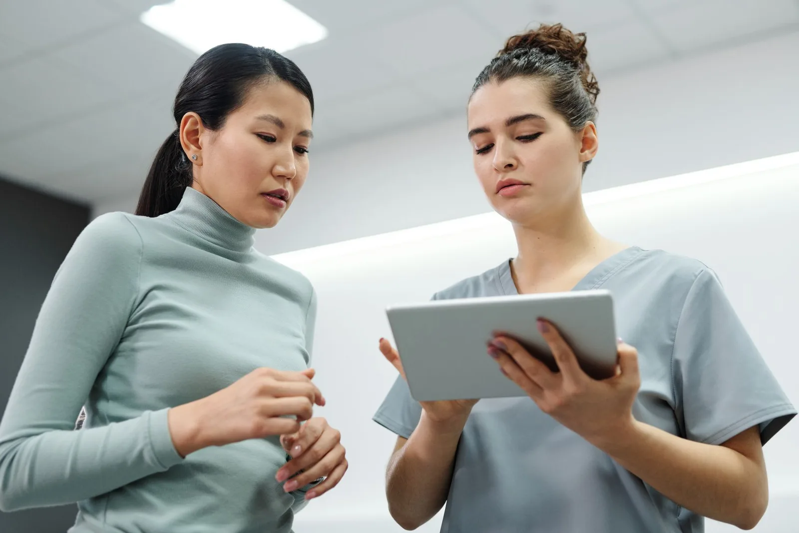 Clinician and patient discussing information on a tablet; illustrative photograph
